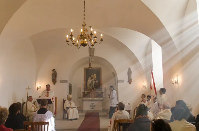 Liturgie v zámecké kapli při svíčkách pod lustrem